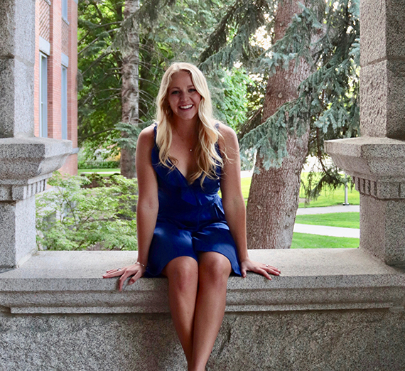 Une femme se tient les bras croisés à côté d’une fenêtre